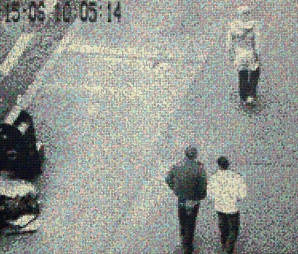 저화질 거리 CCTV. 아래쪽에 두 사람이 걷고, 오른쪽 위에 한 사람이 서 있다